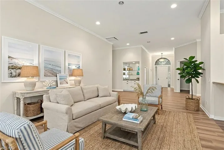 Staged- Living room featuring recessed lighting, wood finished floors, and crown molding