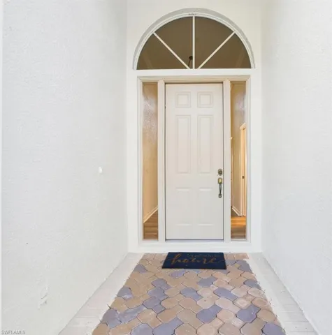 View of exterior entry with a ceiling fan