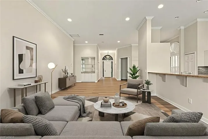 Empty room with wood finished floors, ceiling fan, a sunroom, and a towering ceiling