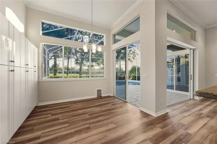 Unfurnished dining area with ornamental molding, dark wood-style floors, and a chandelier