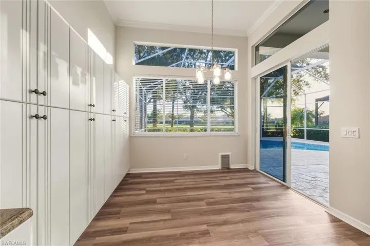 Dining space with vaulted ceiling, a chandelier, dark colored carpet, and recessed lighting