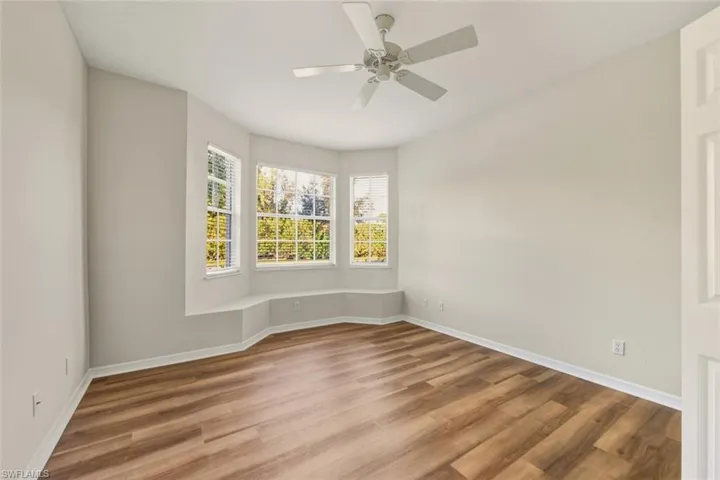 Unfurnished room with light wood finished floors, crown molding, and ceiling fan