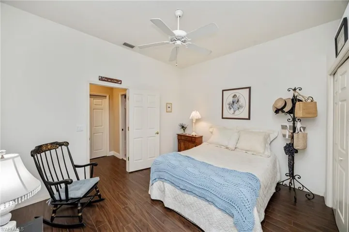 Bedroom with dark wood-type flooring and a ceiling fan