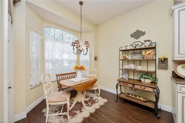 breakfast area with dark wood-style flooring and suspended lighting