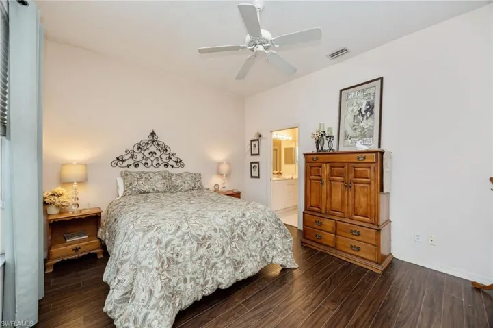 Bedroom with dark wood finished floors, a ceiling fan, and ensuite bathroom