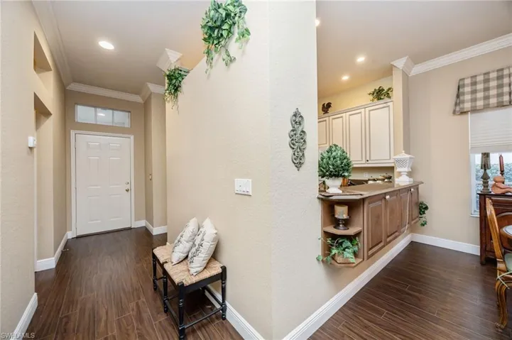 Hallway featuring dark wood-style floors and ornamental molding