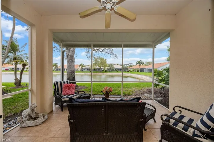 Sunroom / solarium featuring ceiling fan, a water view, and a residential view