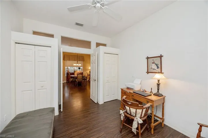 Home office featuring dark wood-type flooring and a ceiling fan