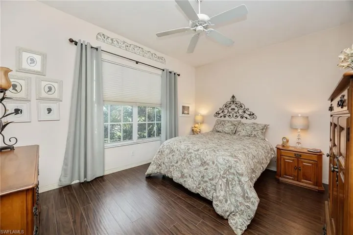 Bedroom with dark wood finished floors and a ceiling fan