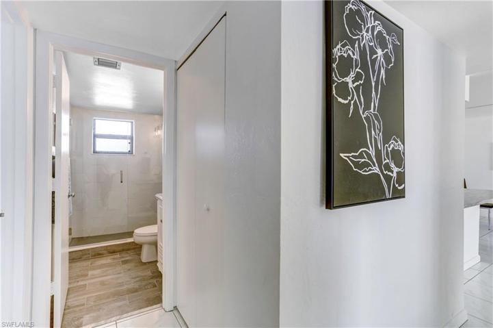 Hallway with washer/dryer closet includes newer stackable washer/dryer.