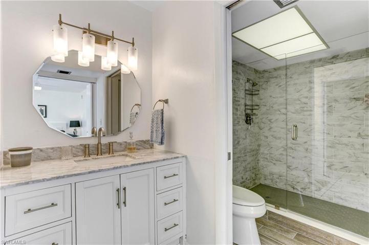 Separate shower with custom tile/glass doors.