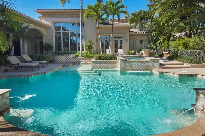 View of swimming pool featuring a patio area, a pool with connected hot tub, and french doors
