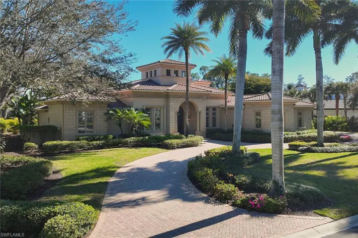 Mediterranean / spanish house with a front yard, a tiled roof, and stucco siding