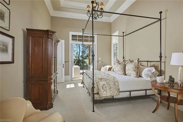 Bedroom with light colored carpet, access to outside, ornamental molding, and a chandelier