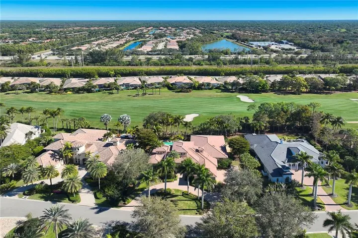 Aerial view of property's location featuring a local golf course and nearby suburban area
