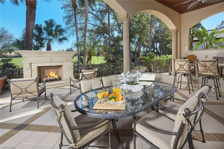 View of patio / terrace with outdoor dining space and a lit fireplace