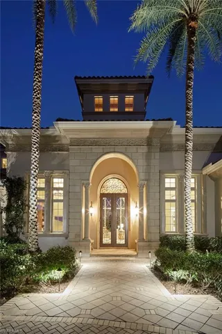 Exterior entry at twilight featuring french doors and stone siding