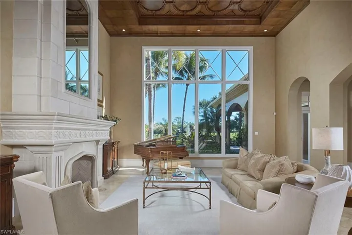 Living area with a high ceiling, arched walkways, and a fireplace
