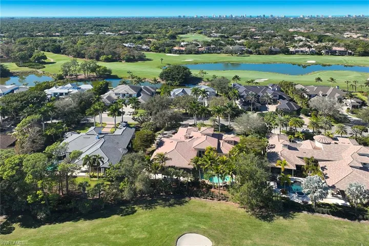 View of property location featuring a golf club, a nearby body of water, and nearby suburban area