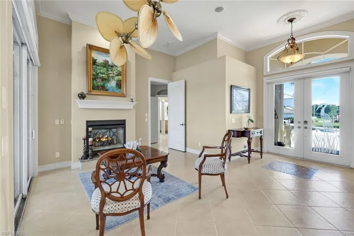 Sitting area steps in the front entry. double sided gas fireplace with view to pool and canal.