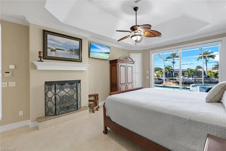 Beautiful Primary with incredible views of pool/canal and a fireplace