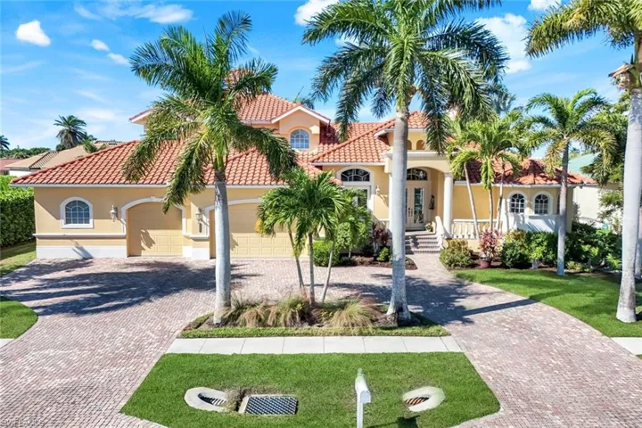 Mediterranean style house featuring decorative driveway, 4 car garage, and a tile roof