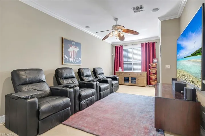 Media room with 85" TV and snack/bar stand.