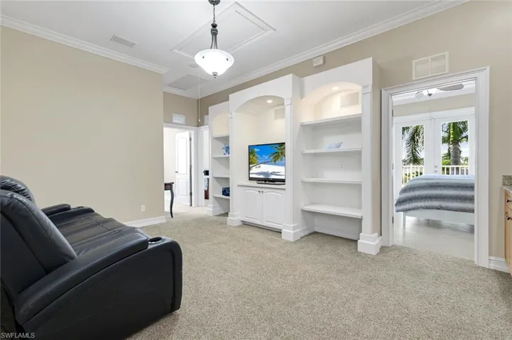 Stairs lead to loft upstairs with built in cabinets, couch, tv.