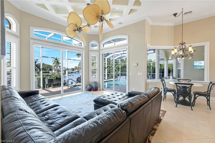 Beautiful views from every seat. Coffered ceiling, ornamental molding, light tile patterned floors, a water view, and beam ceiling