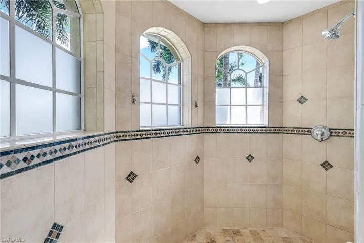 Large walk in shower with two shower heads and large amounts natural light