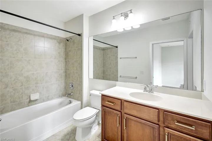 Full bathroom with vanity, tile patterned flooring, toilet, and tiled shower / bath