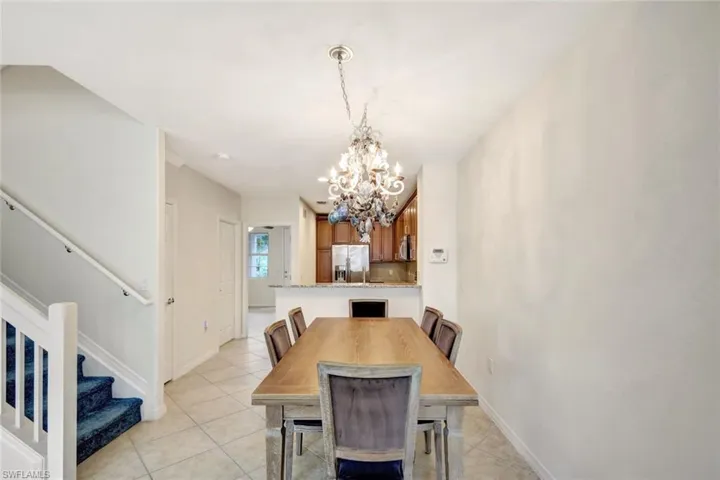 Dining area with light tile patterned floors and a notable chandelier