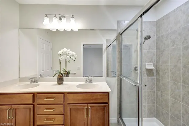 Bathroom featuring vanity and a shower with door