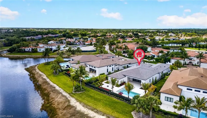 Aerial view of residential area with a pool and a large body of water