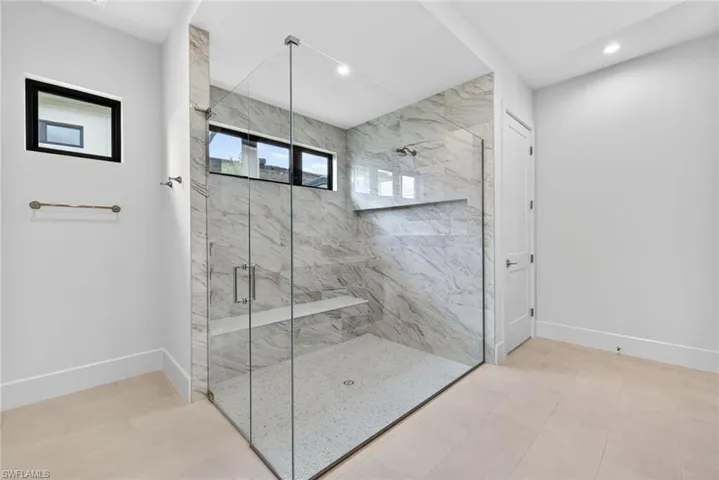Master bathroom featuring a marble finish shower and recessed lighting and nice natural lighting through transom windows