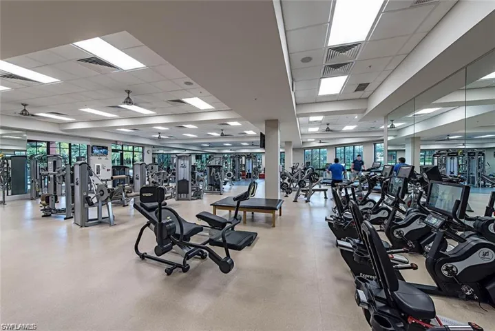 Private beach club dining space with parquet flooring, coffered ceiling, ornamental molding, and wood ceiling walls of windows gives stunning views of the gulf