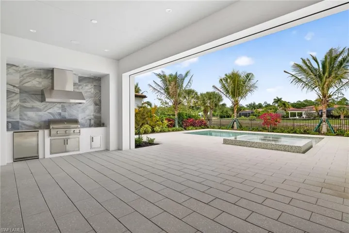 Outdoor kitchen and living Room, large patio area, and an in-ground salt water pool and spa