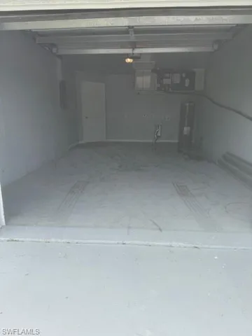 Garage featuring water heater and electric panel