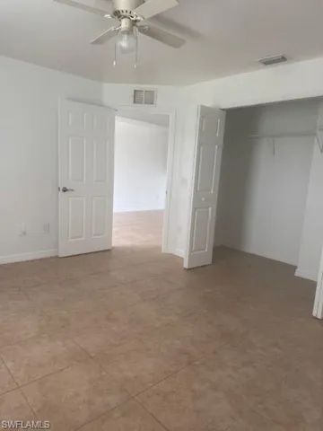 Unfurnished bedroom featuring ceiling fan, a closet, and light tile patterned flooring
