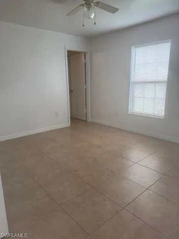Unfurnished room featuring light tile patterned floors and ceiling fan