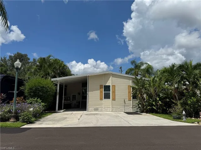 View of front of house with an attached carport and concrete driveway