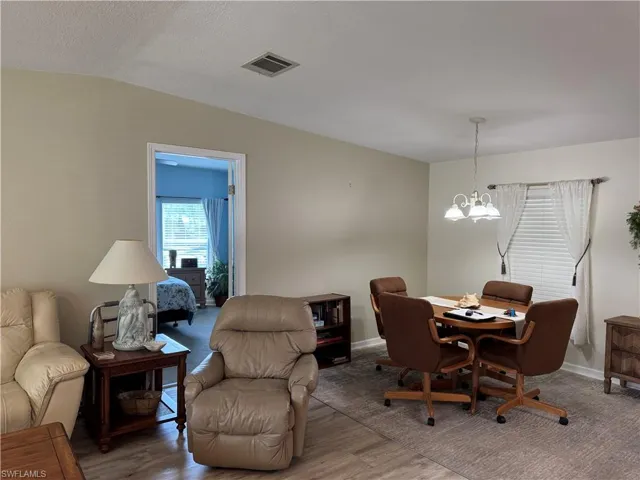 Dining area featuring visible vents, baseboards, light wood-style flooring, and an inviting chandelier