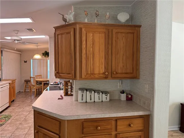 Kitchen featuring brown cabinetry, light countertops, and visible vents