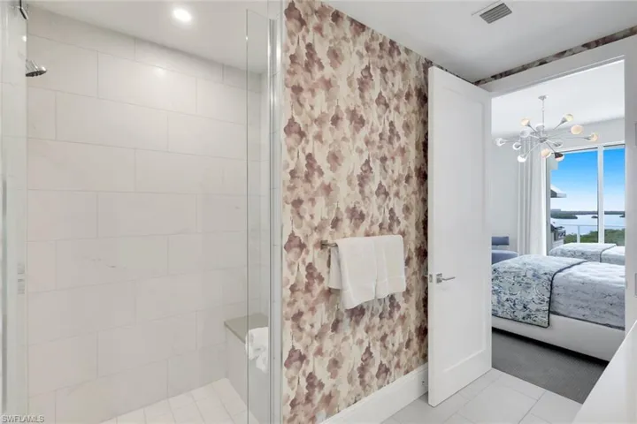 Statement wallpaper and a modern walk-in shower.