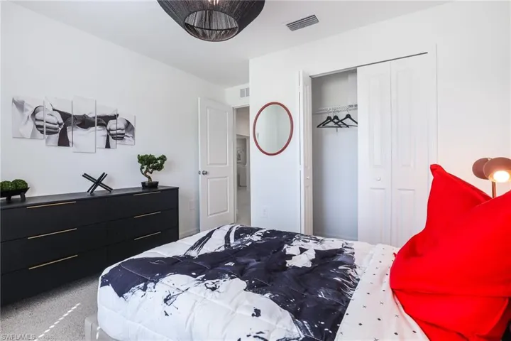 White walls complement the dark wood-finish dresser with gold-tone hardware