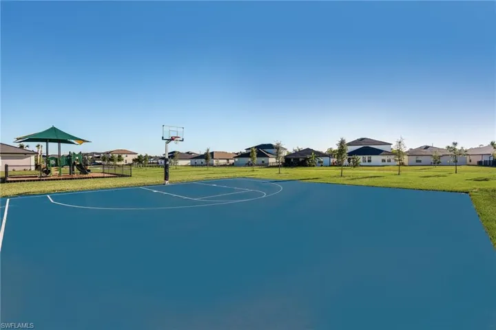 Community basketball court featuring a blue playing surface and a clear backboard