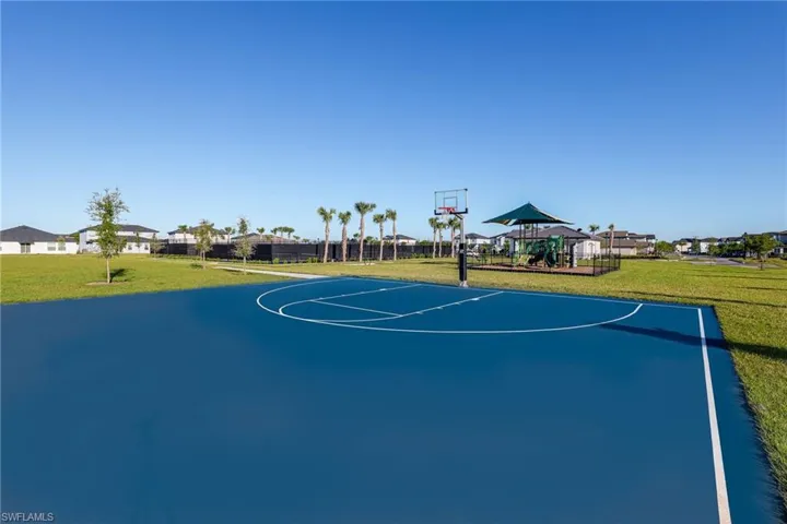 Outdoor recreational area featuring a blue basketball court with white markings