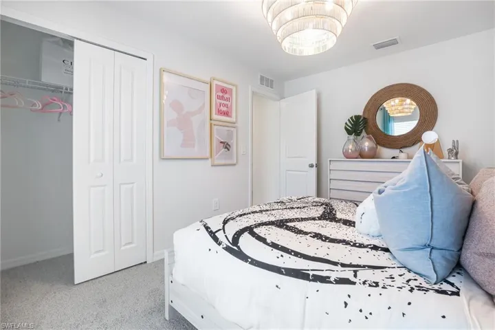 Recessed ceiling light, white bi-fold closet doors, and wall-to-wall carpeting