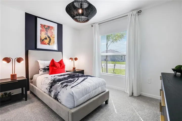Bedroom featuring a window with blinds and curtains, a ceiling-mounted light fixture, and carpeted flooring