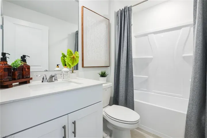 Modern bathroom featuring a white vanity with an integrated sink, chrome faucet, and under-sink cabinetry
